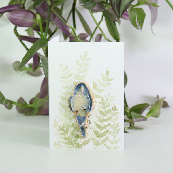 small ceramic and glass dark blue budgie plant decoration, on gift card with watercolour leaves