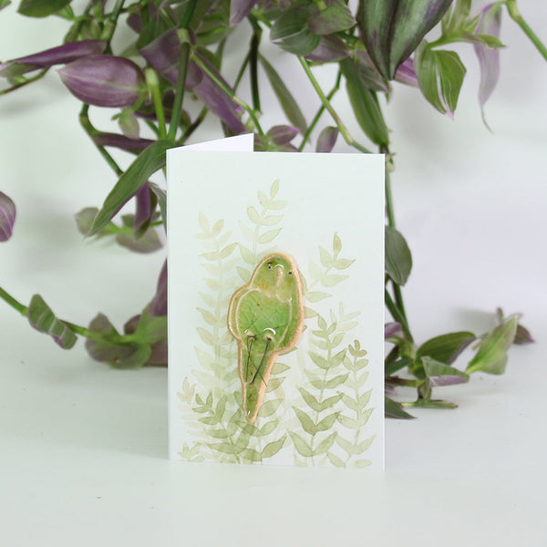 small ceramic and glass green budgie on gift card with watercolour leaves