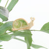 small ceramic and glass emerald green snail plant decoration, with thin wire wrapped around house plant stem