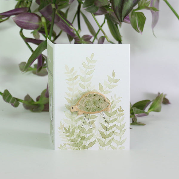 small ceramic and glass hazel tortoise plant decoration, on gift card with watercolour leaves